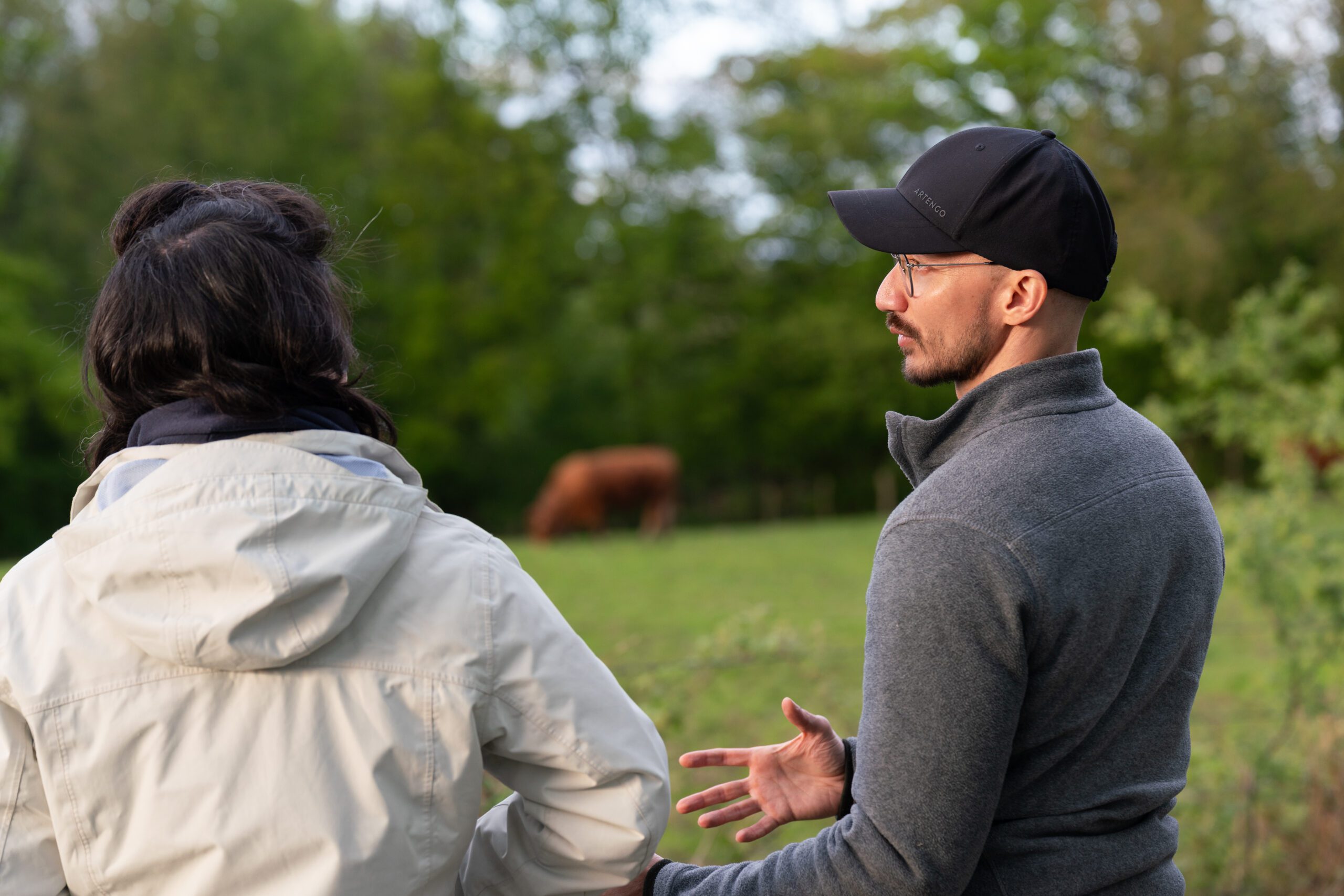 Silvère Dumazel et une éleveuse discutant devant un pâturage de vaches